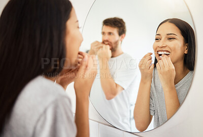 Buy stock photo Mirror, dental floss and teeth healthcare couple cleaning mouth for healthy gums, smile and fresh breath. Man and woman in bathroom flossing morning during routine for dental hygiene in the morning