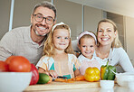 Family, health and kids with vegetables nutrition for healthy diet, minerals or vitamins on kitchen table at home. Portrait of happy parents and girls with food and veggies for growth and wellness.
