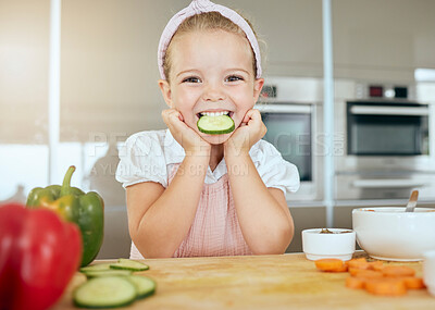 Buy stock photo Cute girl with a smile eating cucumber, cooks healthy green salad for a meal and learning about nutrition benefits. Fresh fruit, organic vegetables and natural food is important for child development
