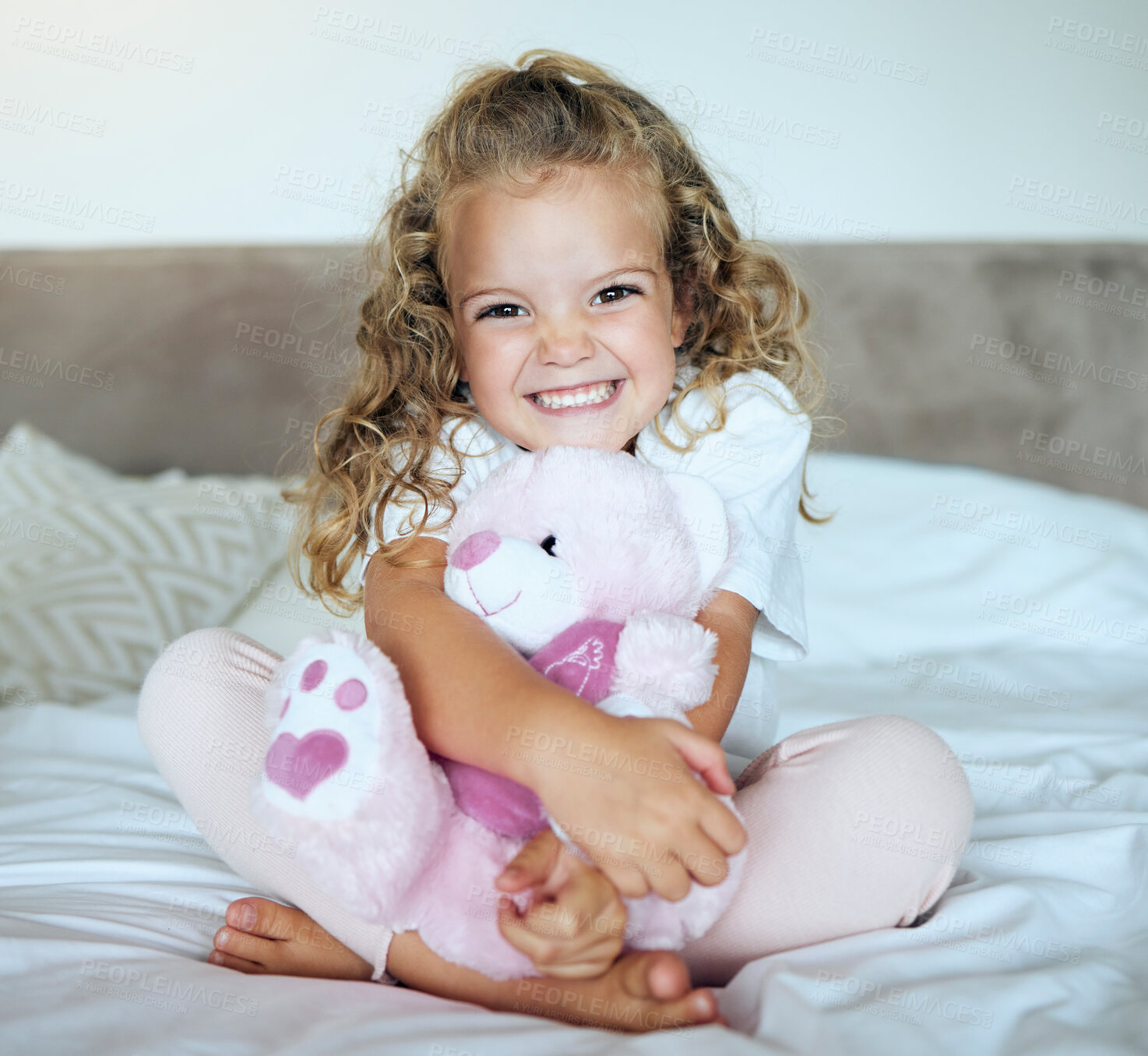 Buy stock photo Children, teddy bear and girl child hug her stuffed animal with a smile in her house. Portrait of kid, happy and safe with an adorable or cute female holding a fluffy toy sitting on a bed