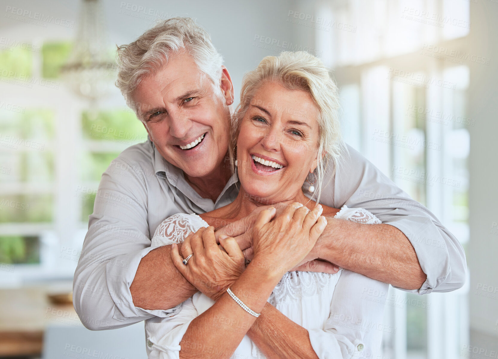 Buy stock photo Love, couple and retirement with a senior man and woman looking happy and hugging in their home together. Smile, romance and relationship with an elderly male and female pensioner in a house