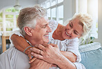 Love, happy and senior couple hug and bonding on sofa, smile and relax in home together. Retirement, freedom and happy man and woman sharing a romantic embrace, enjoying conversation and relationship
