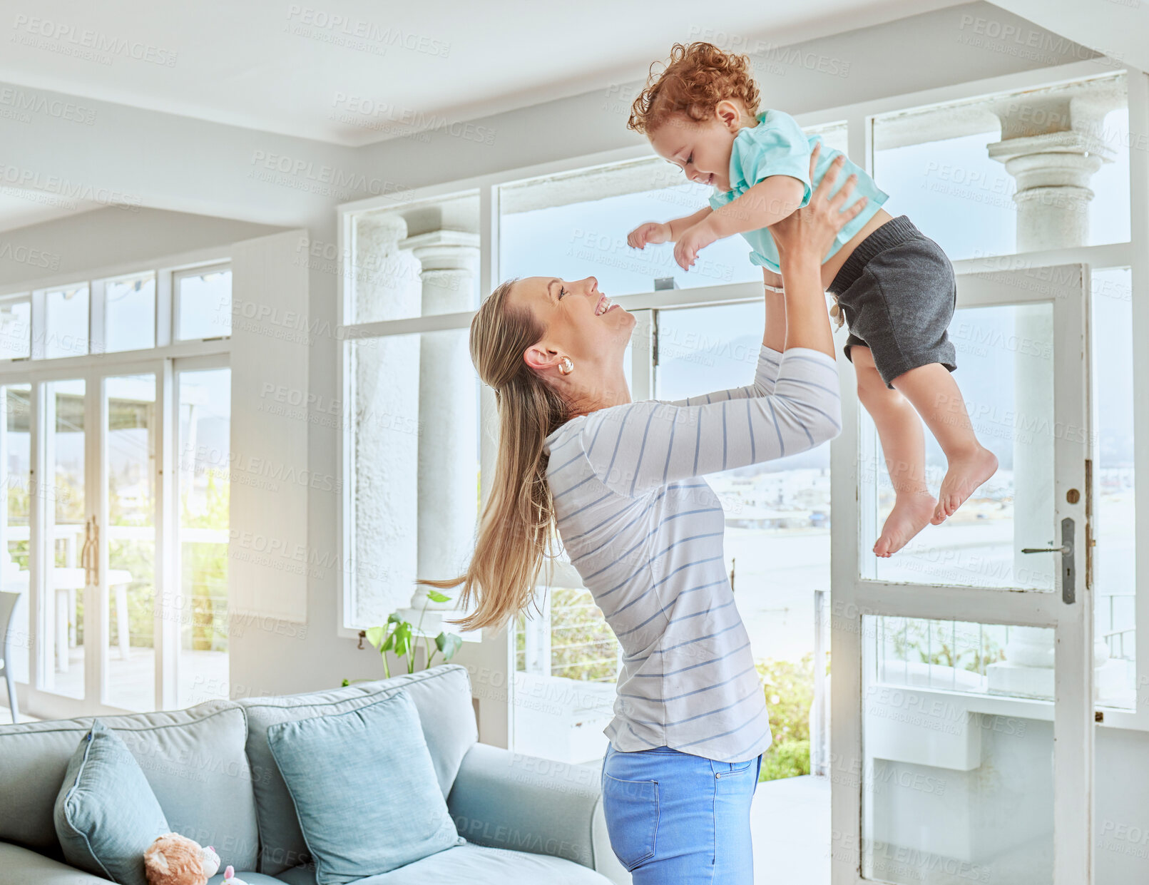 Buy stock photo Family, love and energy with mother and son playing, bonding and lifting toddler in air for fun in lounge at home. Happy woman and boy child being playful and enjoying time together in a bright room