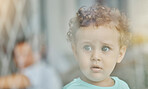 Baby, eyes and surprise by window with wonder on face in home, toddler and looking into distance while alone. Child, boy or girl with wow facial expression, ginger hair and blurry background at house