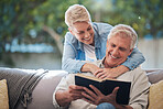 Mature couple, bond and funny book on house or home sofa in garden and backyard patio. Smile, happy or relax senior man and elderly woman in retirement hug, trust or security love marriage with novel