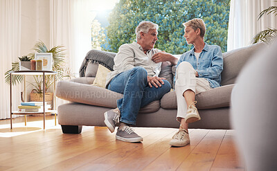 Buy stock photo Senior couple, serious talk and communication about problems and marriage issues while sitting on the sofa at home. Mature man and woman talking and discussing issues, trouble and divorce