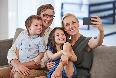 Buy stock photo Family, happy and phone selfie on the sofa and smile for a social media post. Mother, father and kids together, bonding and carefree weekend in the living room and taking a picture with smartphone