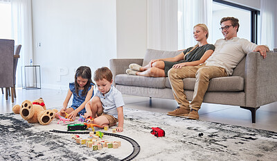 Buy stock photo Parents on sofa, happy and watch children with toys on the living room floor and home. Mom relax with dad on couch in lounge, as boy and girl kids have fun together on carpet in family house