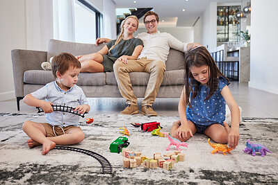 Buy stock photo Family home, parents and children with toys on carpet in living room for holiday with mother and father love, care and happiness. Relax mom, dad on couch while baby or kids play together on the floor