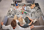 Family, children and living room with a girl and boy playing on the floor of their home while their parents relax on the sofa. Toy, fun and game with a brother and sister bonding with mom and dad