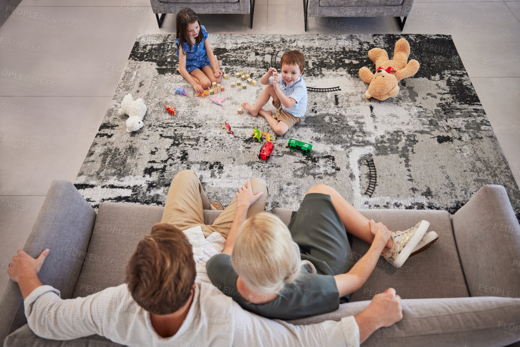 Buy stock photo Family, children and living room with a girl and boy playing on the floor of their home while their parents relax on the sofa. Toy, fun and game with a brother and sister bonding with mom and dad
