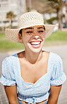 Travel hat and summer girl with smile enjoying warm outdoor sunshine vacation weather. Young, beautiful and happy latino woman relaxing on walkway with natural sunlight face protection.