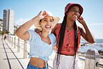 Summer, fashion and gen z girl friends in the city near the beach or ocean for holiday, vacation or youth wellness. Vitamin d, happiness and love with young women wearing hat outdoor in the sunshine
