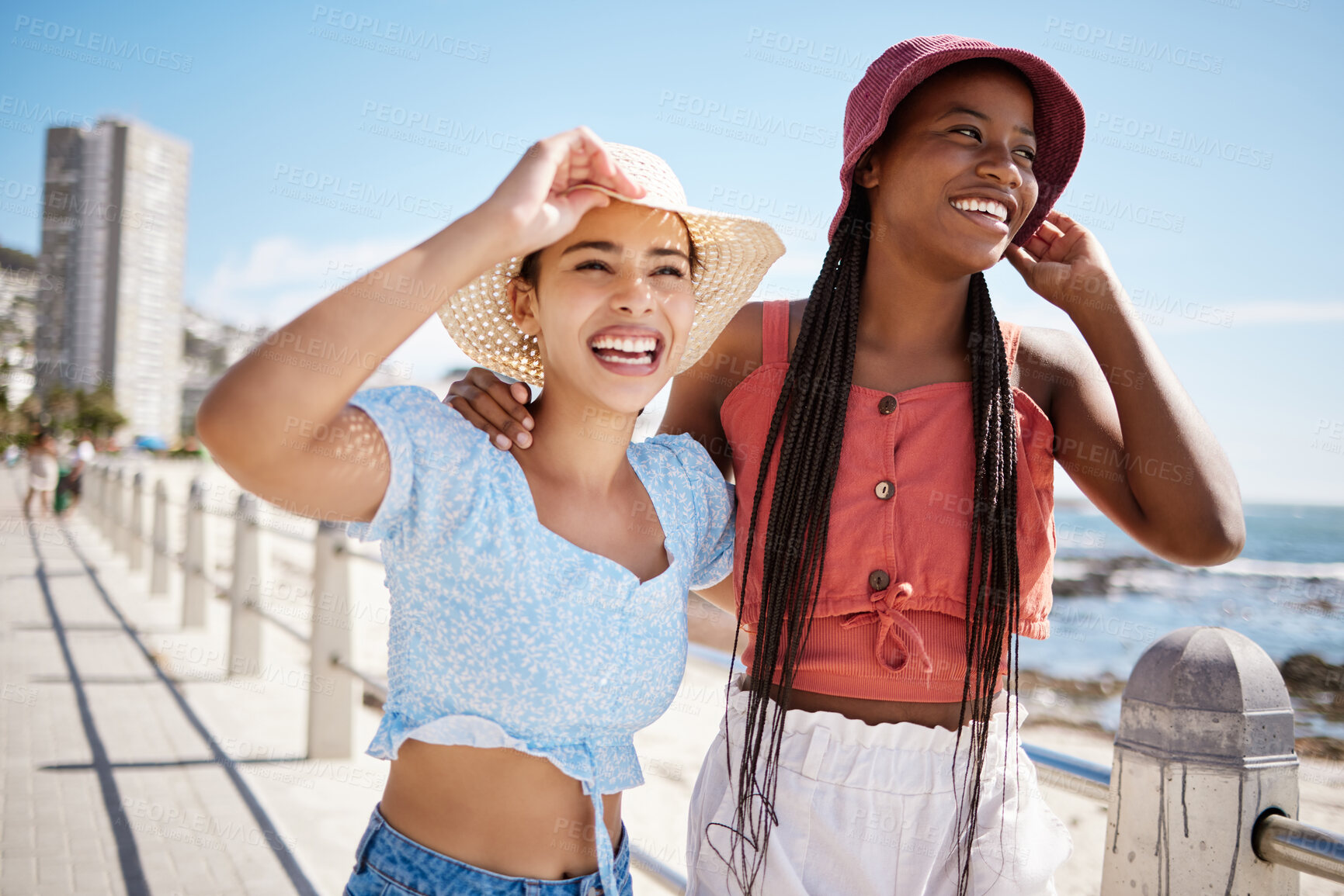 Buy stock photo Summer, fashion and gen z girl friends in the city near the beach or ocean for holiday, vacation or youth wellness. Vitamin d, happiness and love with young women wearing hat outdoor in the sunshine
