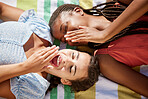 Gossip, picnic and friends relaxing on a blanket outdoors with a shock expression on face. Freedom, diversity and young woman telling her friend a secret while laying outside on a summer vacation.