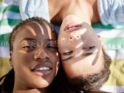 Buy stock photo Summer, selfie and a girl and girlfriend at the beach lying on a towel, shadow of hands in face. Pride, lgbt and  young woman best friends or lesbian couple relax in sun by the ocean on the weekend.