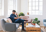 Attractive man reading sitting on couch at home