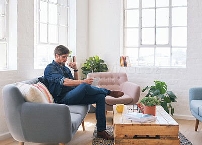 Buy stock photo Young man reading on living room sofa, digital tablet document or learning information in book. Modern apartment interior, online lifestyle magazine with technology and person relax on couch in home