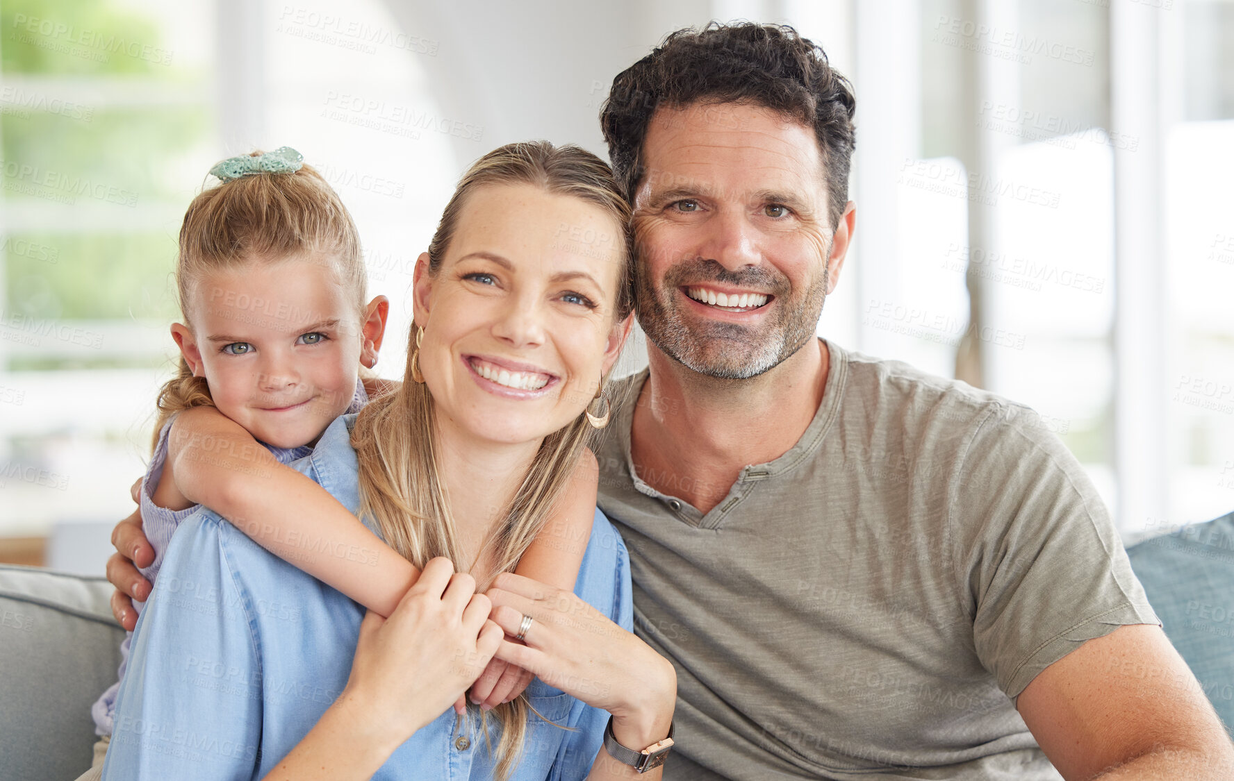 Buy stock photo Children, family and love with a girl and her parents on a sofa in the living room of their home together. Mother, father and daughter looking happy with a smile and bonding on a couch in the house