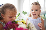 Excited, wow and children looking surprised looking at flower bouquet surprise for birthday, mothers day or valentines day. Girl kids or sibling sisters happy and playful with spring flowers at home