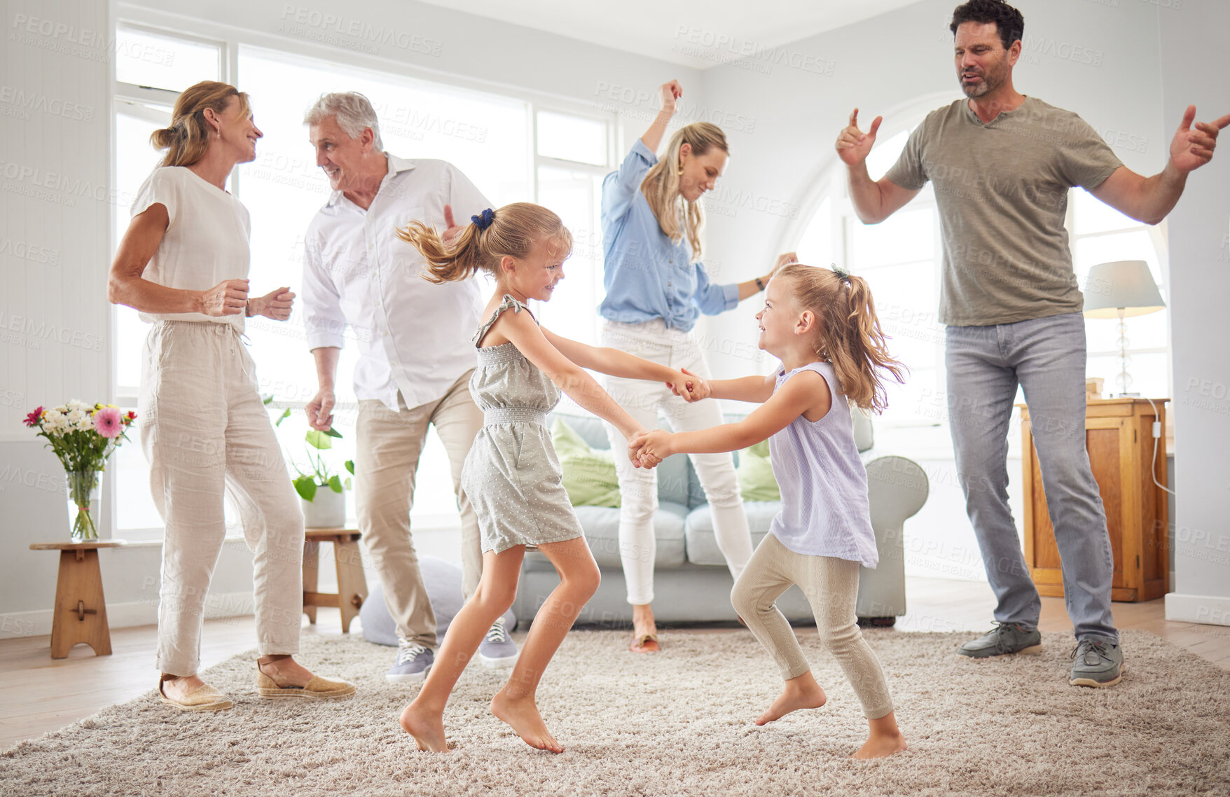 Buy stock photo Happy, dance and love with big family in living room together for crazy, energy and excited. Lifestyle, freedom and celebration dancing at modern home with parents, children and grandparents