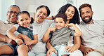 Family on sofa smile with couple, children and their grandparents in home living room. Group of people with kids and parents, sit on couch with happy grandma and grandpa while on vacation together