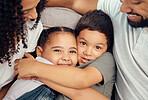 Portrait, happy family and children hug and bonding on a sofa, happy and relax with mother and father at home. Smile, relax and embracing kids enjoying a playful day with loving, caring parents