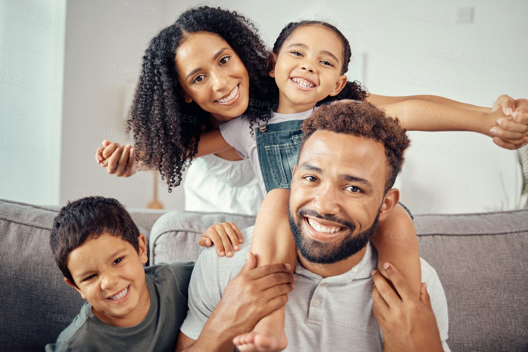 Buy stock photo Mom, dad and kids, a happy family on a sofa in living room at home. Mother, father and children smile, sitting on couch together. Portrait of a man and woman with smiling kids, a celebration of love