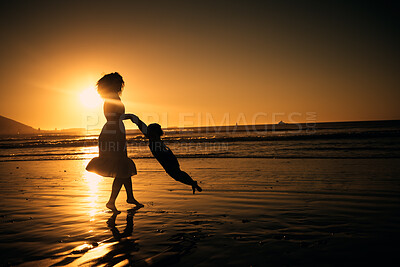 Buy stock photo Sunset, beach and silhouette of a mother and girl playing on the sand while on summer vacation. Family, fun and happy woman swinging her child in nature by the ocean while on holiday in south africa.