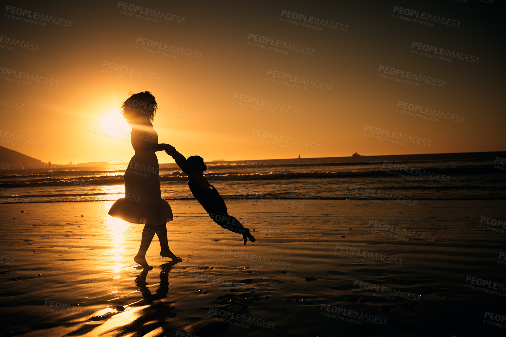 Buy stock photo Sunset, beach and silhouette of a mother and girl playing on the sand while on summer vacation. Family, fun and happy woman swinging her child in nature by the ocean while on holiday in south africa.
