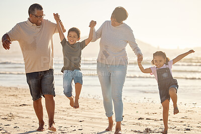 Buy stock photo Happy, kids and grandparents with energy and jump playing at the beach on a fun family day at sea on holiday vacation together. Excited children bonding with their grandmother and grandfather outdoor