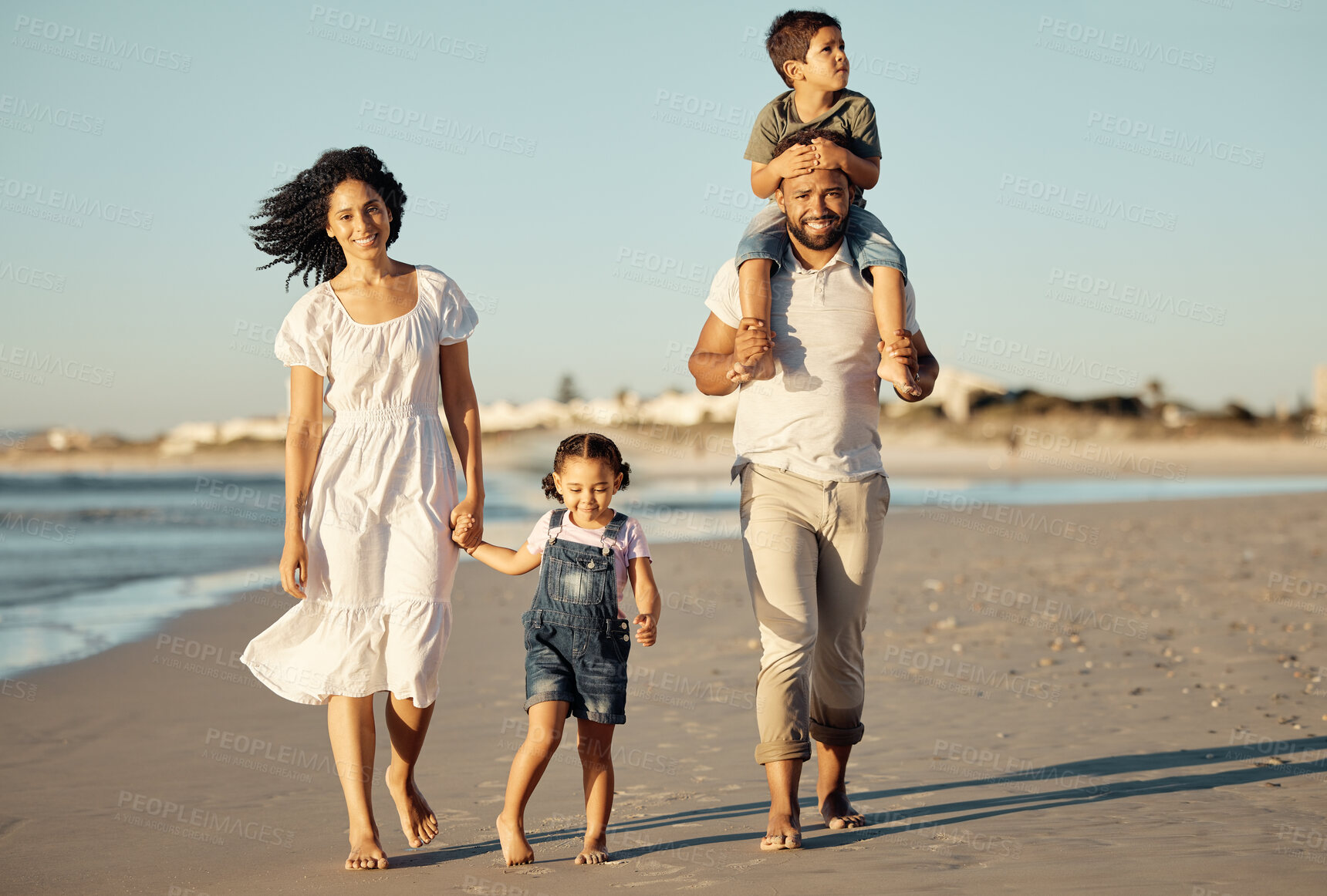 Buy stock photo Travel, freedom and happy family at the beach, walking and bonding on ocean trip together. Portrait of loving parents enjoying fun getaway with their children, caring and playing on a walk at sunset