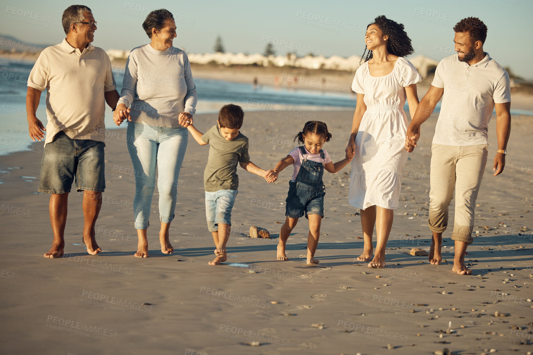 Buy stock photo Big family walking on the beach together with grandparents, children and mom, dad for wellness, exercise and healthy lifestyle. Retirement couple and people with children for outdoor fun in summer