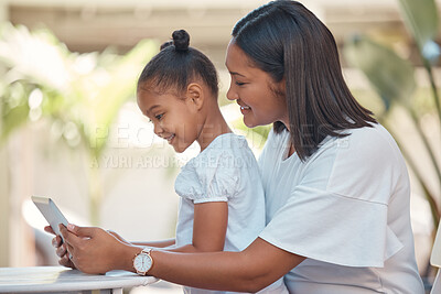 Buy stock photo Mother, girl and tablet streaming cartoon, video or education game for children while sitting outdoor. Latin woman and her young daughter watching funny children movie online with technology