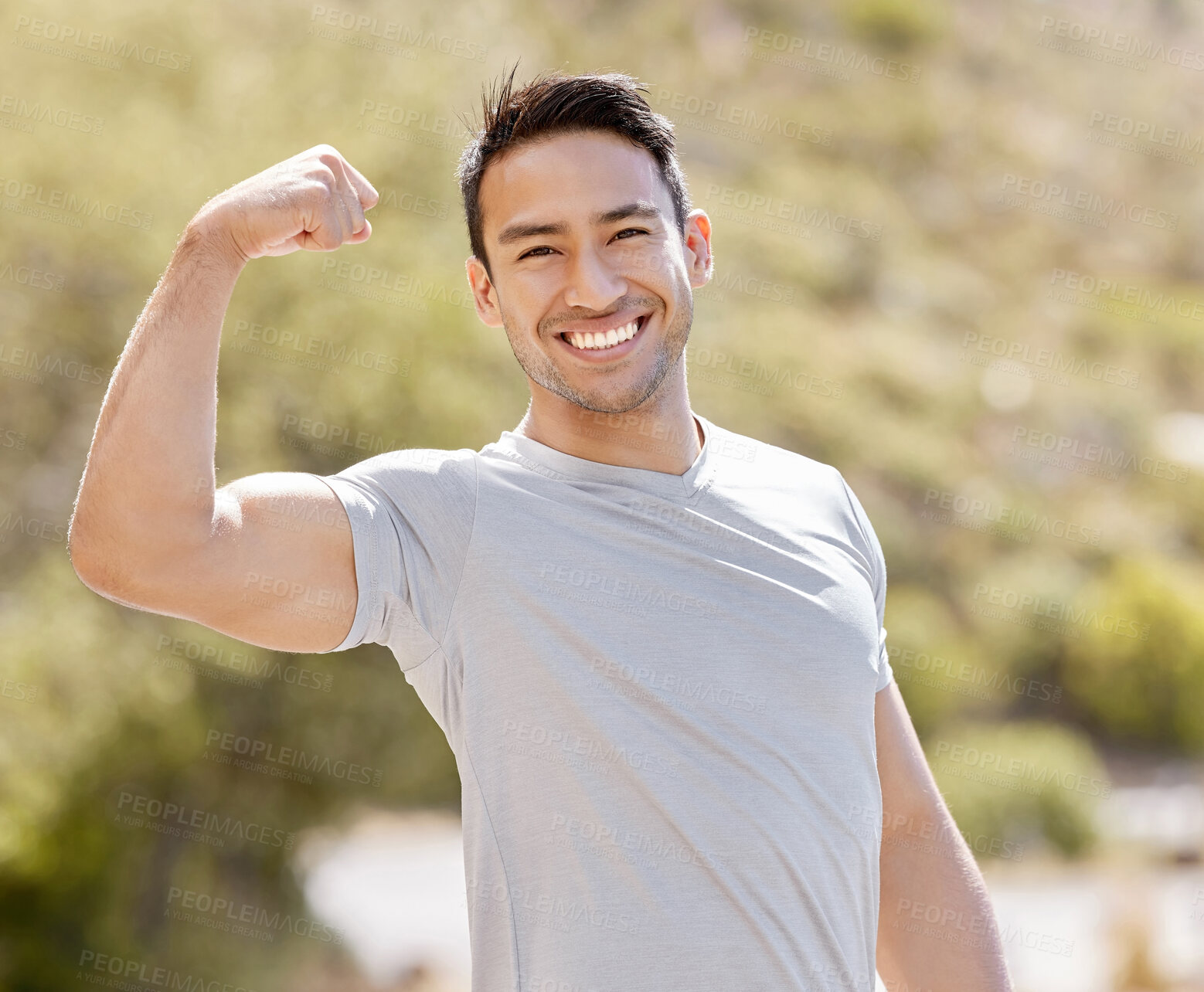 Buy stock photo Fitness, nature and a man flexing biceps with a smile while training in outdoor park. Power, flex and stretch before workout or run. Wellness, sports and health, a runner ready for running exercise  