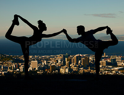 Buy stock photo Silhouette of couple stretching and doing yoga at sunrise in the city. Man and woman training, exercising and doing workout together at sunset. People holding hands in yoga pose with city background