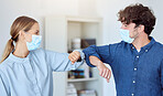 Business team, elbow bump and covid compliance with employees greeting with social distance in an office. Man and woman in the office during coronavirus wearing a face mask and working after lockdown