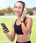 Headphones, fitness and smartphone with woman listening to motivation podcast or music outdoor on sports field with portrait. Athlete girl with 5g cellphone and audio for workout training or exercise