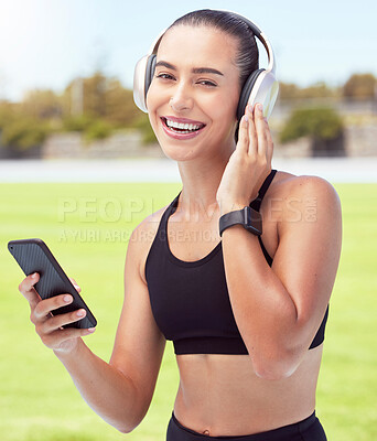 Buy stock photo Headphones, fitness and smartphone with woman listening to motivation podcast or music outdoor on sports field with portrait. Athlete girl with 5g cellphone and audio for workout training or exercise