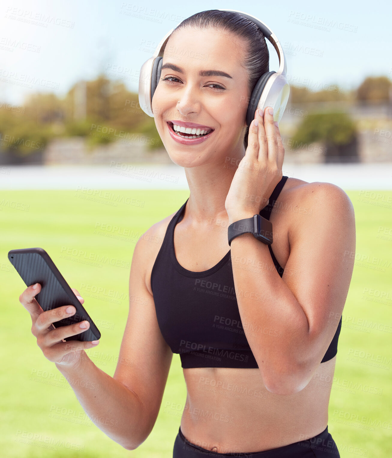 Buy stock photo Headphones, fitness and smartphone with woman listening to motivation podcast or music outdoor on sports field with portrait. Athlete girl with 5g cellphone and audio for workout training or exercise