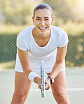 Portrait of a tennis woman with a racket on the tennis court, getting ready for a match. Young tennis player holding a tennis racket, smiling and in a forward bend position for sports game.