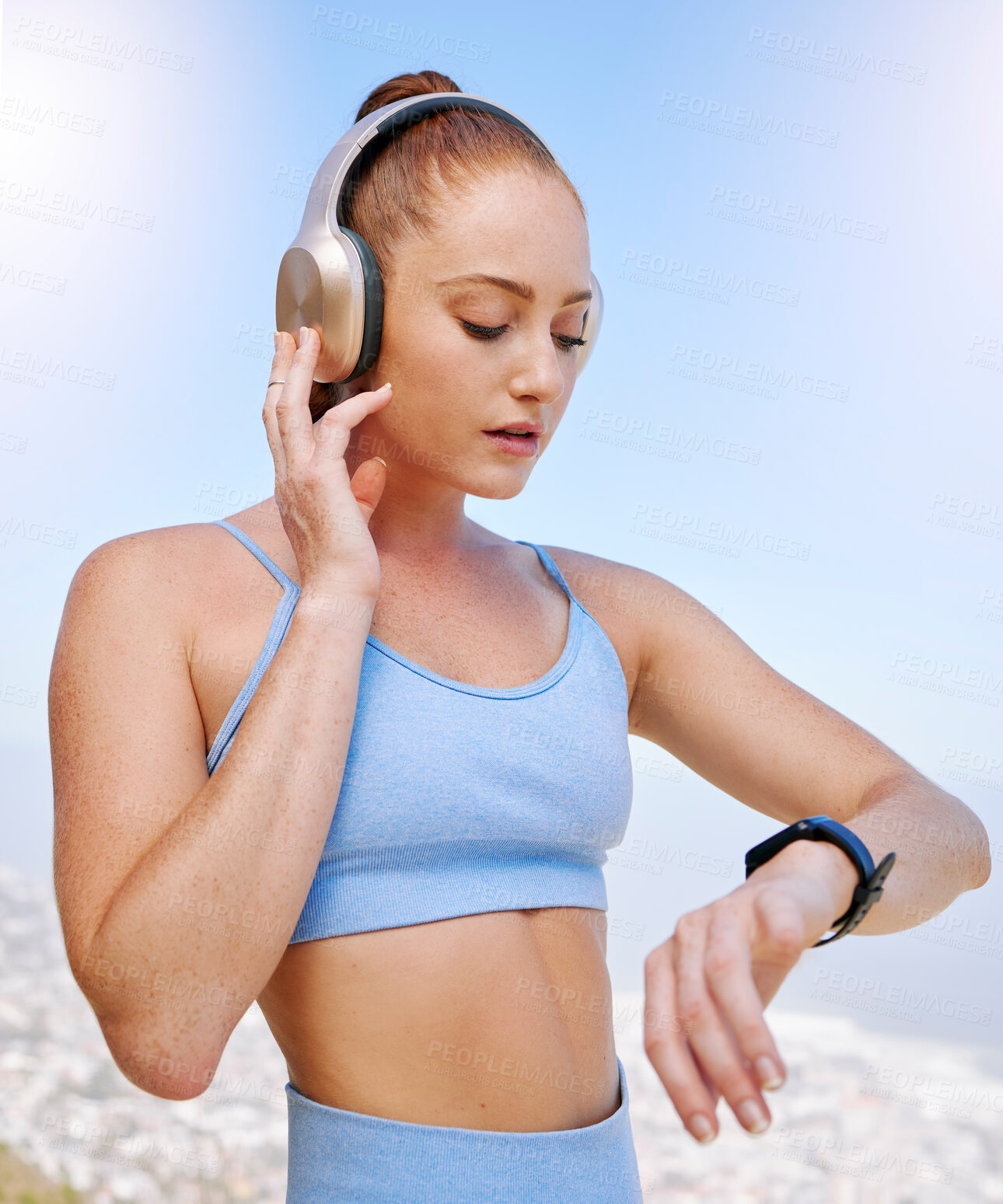 Buy stock photo Fitness, runner and woman on time by her smartwatch as she monitors her performance, heartbeat and pulse outdoors. Headphones, health and girl running in summer streaming music, radio song or podcast