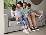 Happy family relax on home sofa in Brazil, parents smile at children on casual day together. Lounge in living room, young african kids bond with black mother and funny father make dad jokes on couch