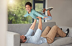 Happy family, love and father and son bonding on a sofa at home, playing and being creative with a fun game. Energy, fantasy and airplane pose by happy boy enjoying free time with his caring dad