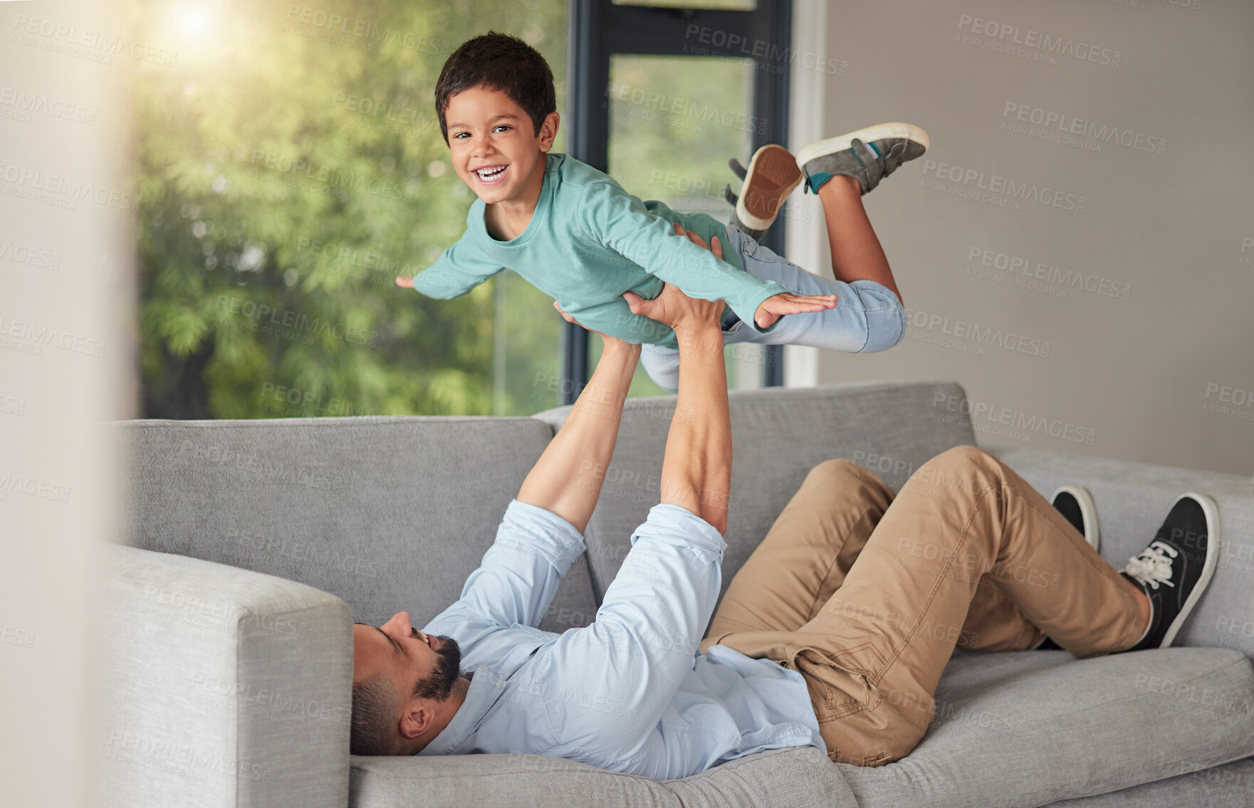 Buy stock photo Happy family, love and father and son bonding on a sofa at home, playing and being creative with a fun game. Energy, fantasy and airplane pose by happy boy enjoying free time with his caring dad