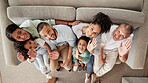 Family, children and wave with kids, grandparents and parents sitting on a sofa in the living room of their home together from above. Happy, smile and love with a senior man, woman and relatives