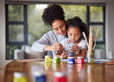 Buy stock photo Learning, mother and child painting for an art preschool project with a young mom helping her daughter at home. Kindergarten, love and creative painter with brush teaching and drawing with a girl