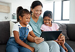 Happy mother and children with digital tablet watch funny videos, movies. or games on the home sofa. Family enjoy watching comedy cartoon with tech with online subscriptions  in the living room