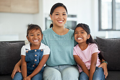 Buy stock photo Happy, smile and portrait of a mother and children sitting on a sofa at home in Indonesia. Happiness, love and mom embracing her girl kids while relaxing on a couch together in their living room.
