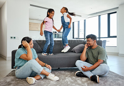 Buy stock photo Family, energy and kids jumping on home sofa with tired parents struggling with naughty, hyperactive and playing children. Woman and man with ADHD, noisy and laughing girls, friends or fun twins